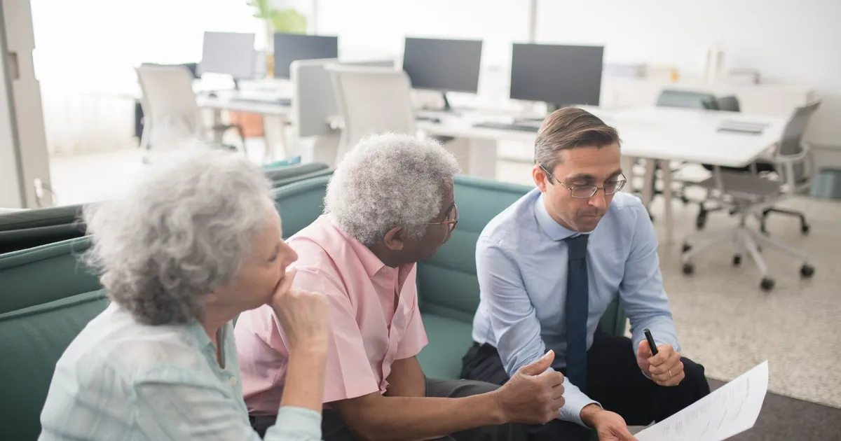 Senior couple at a kitchen table reviewing debt relief for seniors options on a laptop