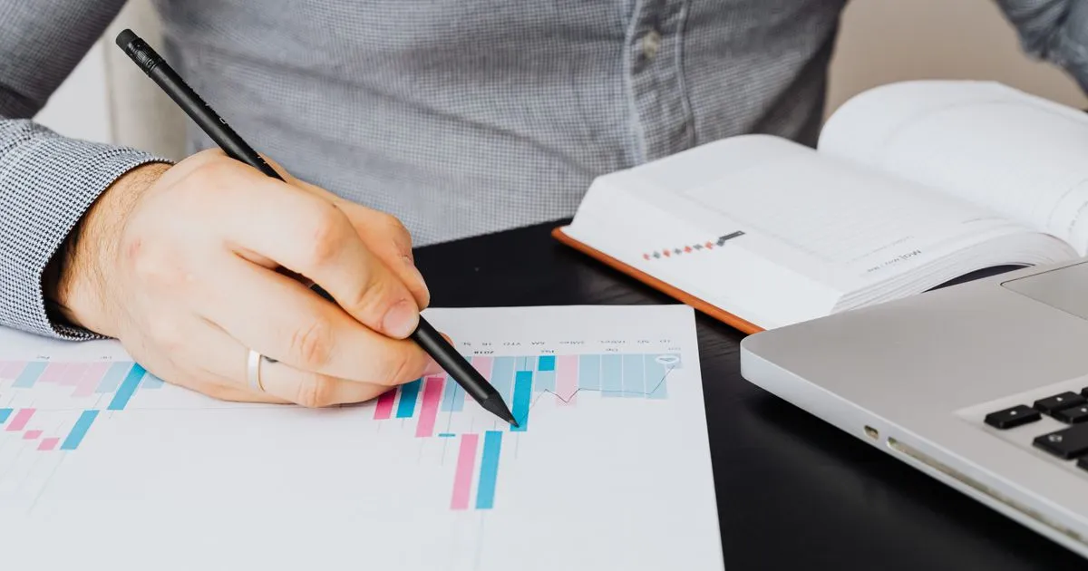 Reviewing a debt relief repayment chart and planner at a desk in Canada