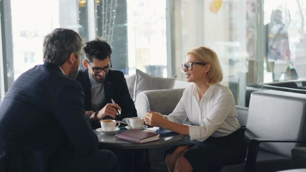 Calm meeting between a Canadian couple and a licensed advisor reviewing debt relief paperwork